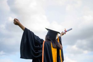 long-haired-female-students-wearing-black-ruffle-dresses-expressing-joy-graduation-university-min
